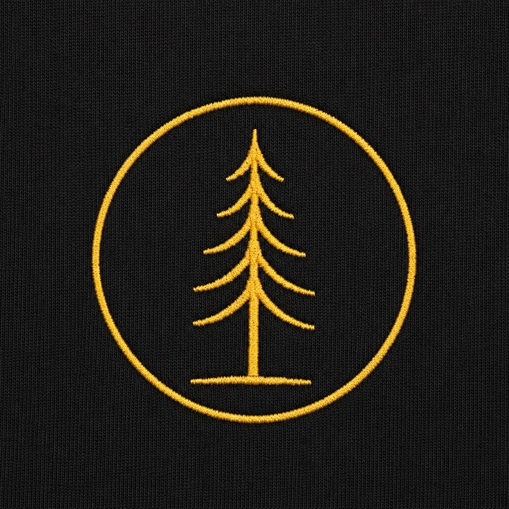 Close-up of the gold embroidered EVAREN tree emblem on black hoodie fabric