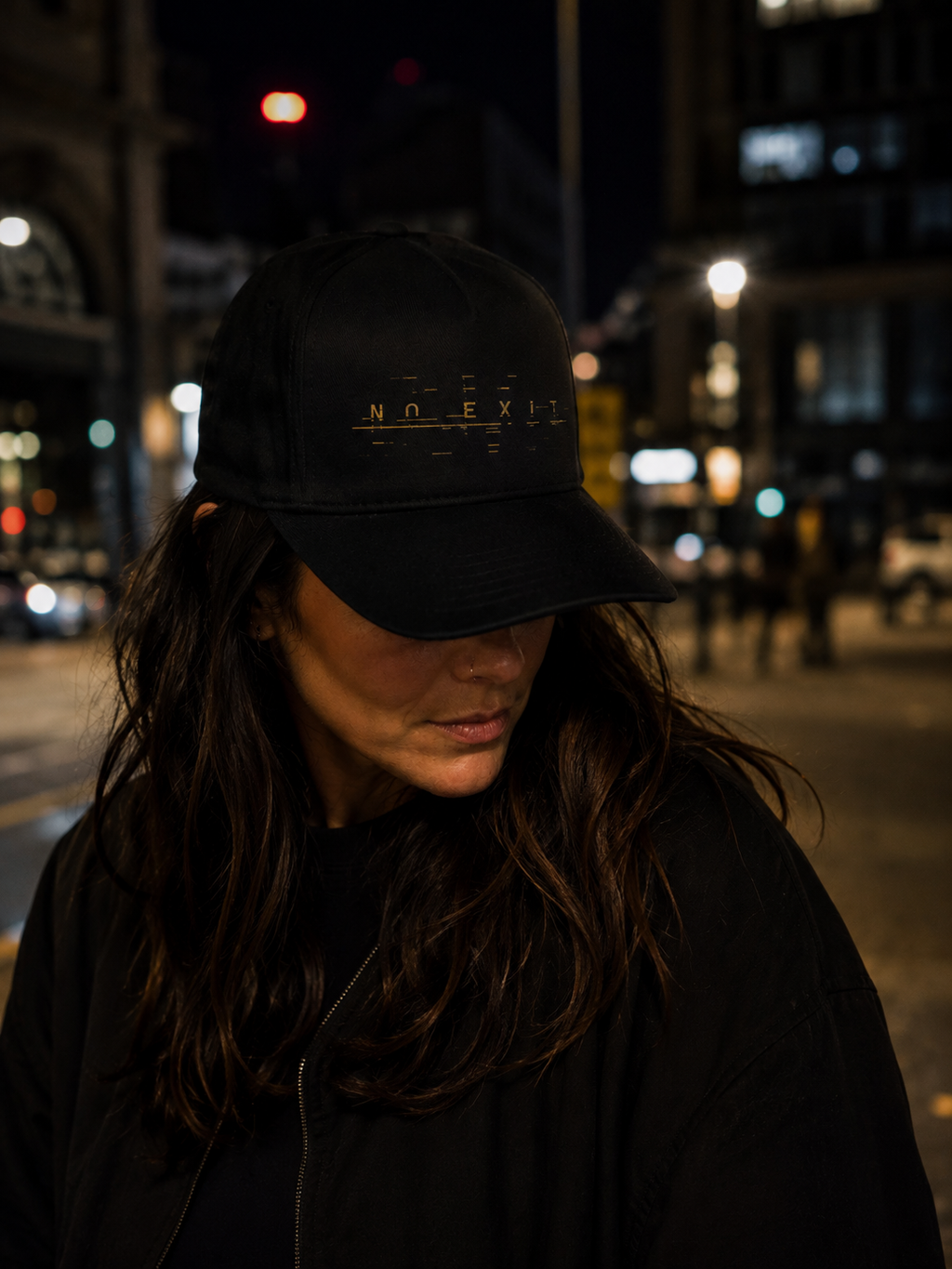 Woman wearing The NO EXIT Cap on a city street at night