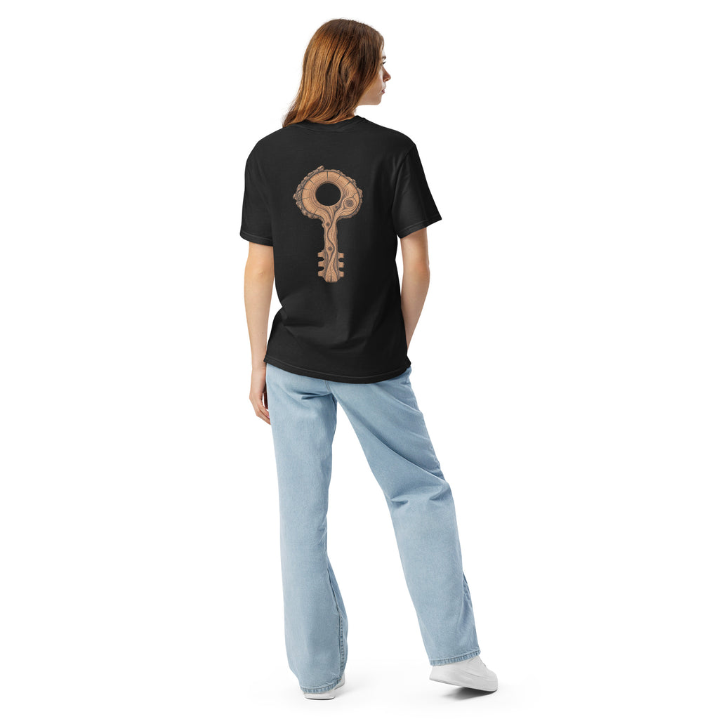 Woman wearing The Key Within Tee from behind, showing the placement and scale of the wood-grain key graphic on the black tee.