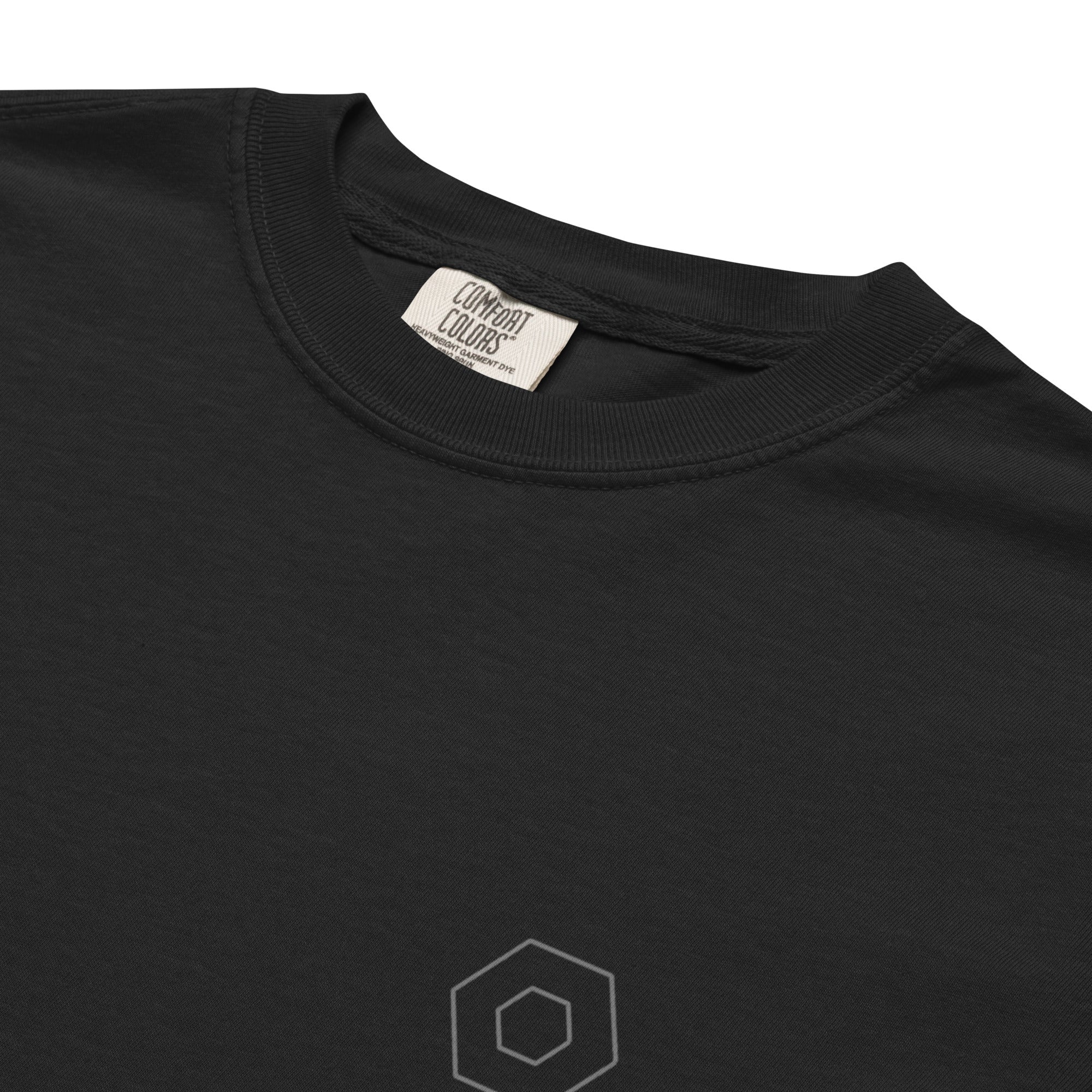 Close-up of the small geometric chest symbol and garment-dyed fabric of The Way Through Tee.