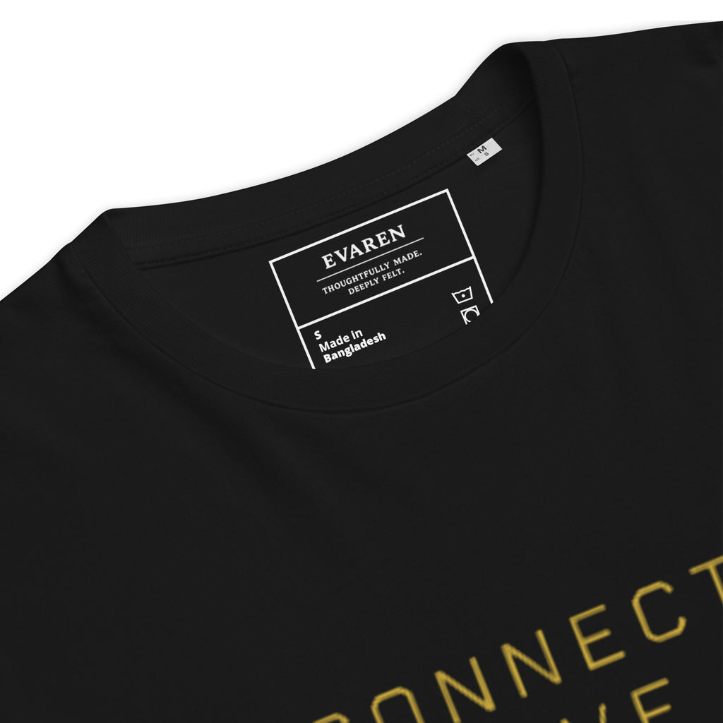 Close-up of The Human Protocol Tee showing the custom white-on-black EVAREN inside neck label and gold front typography.