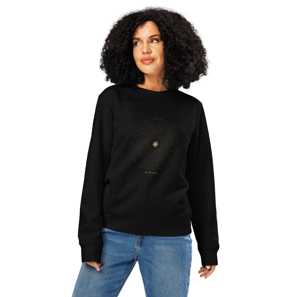 Woman wearing The Echoes Sweatshirt in black, showing the relaxed fit and antique-gold concentric ring front graphic.