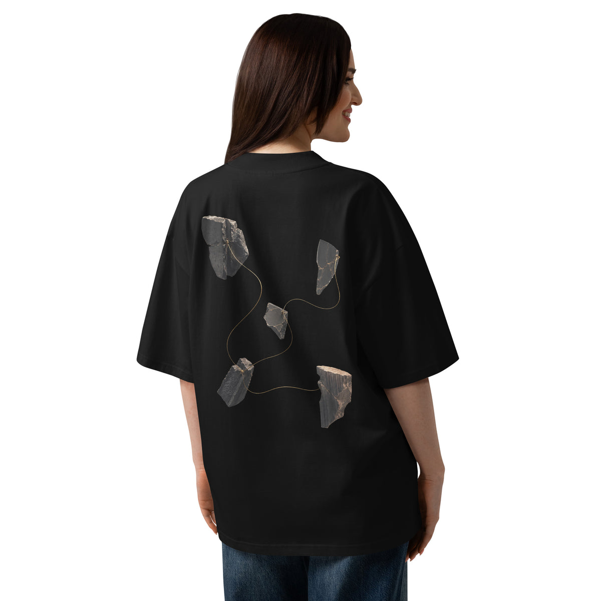 The Thread Remains Tee worn by a woman, showing the back graphic placement and oversized fit.
