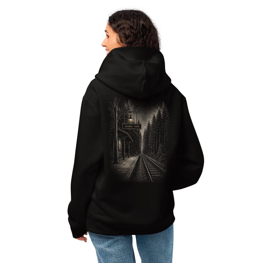 Woman wearing the black oversized EVAREN Headed There Hoodie from the back, showing the railway graphic placement and fit.