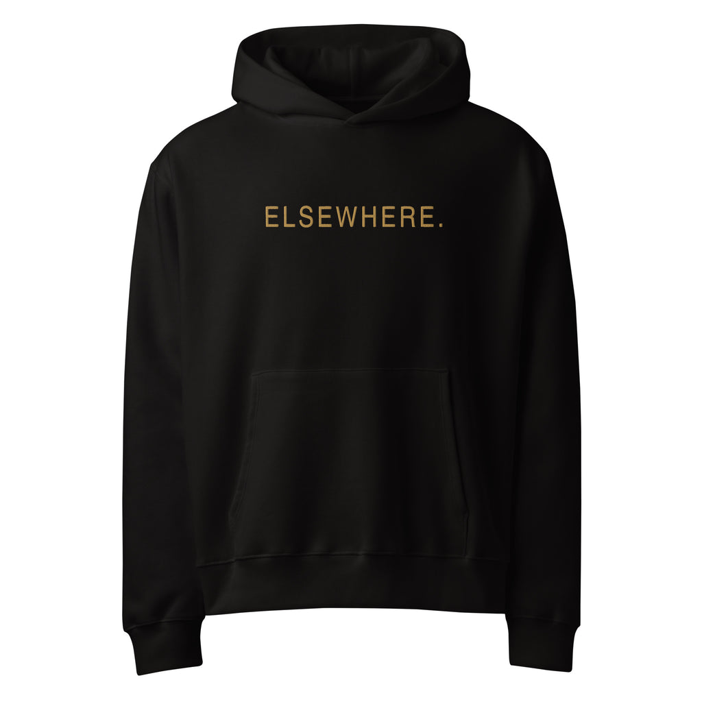 Front view of The Elsewhere Hoodie in black with muted-gold ELSEWHERE. flat embroidery.