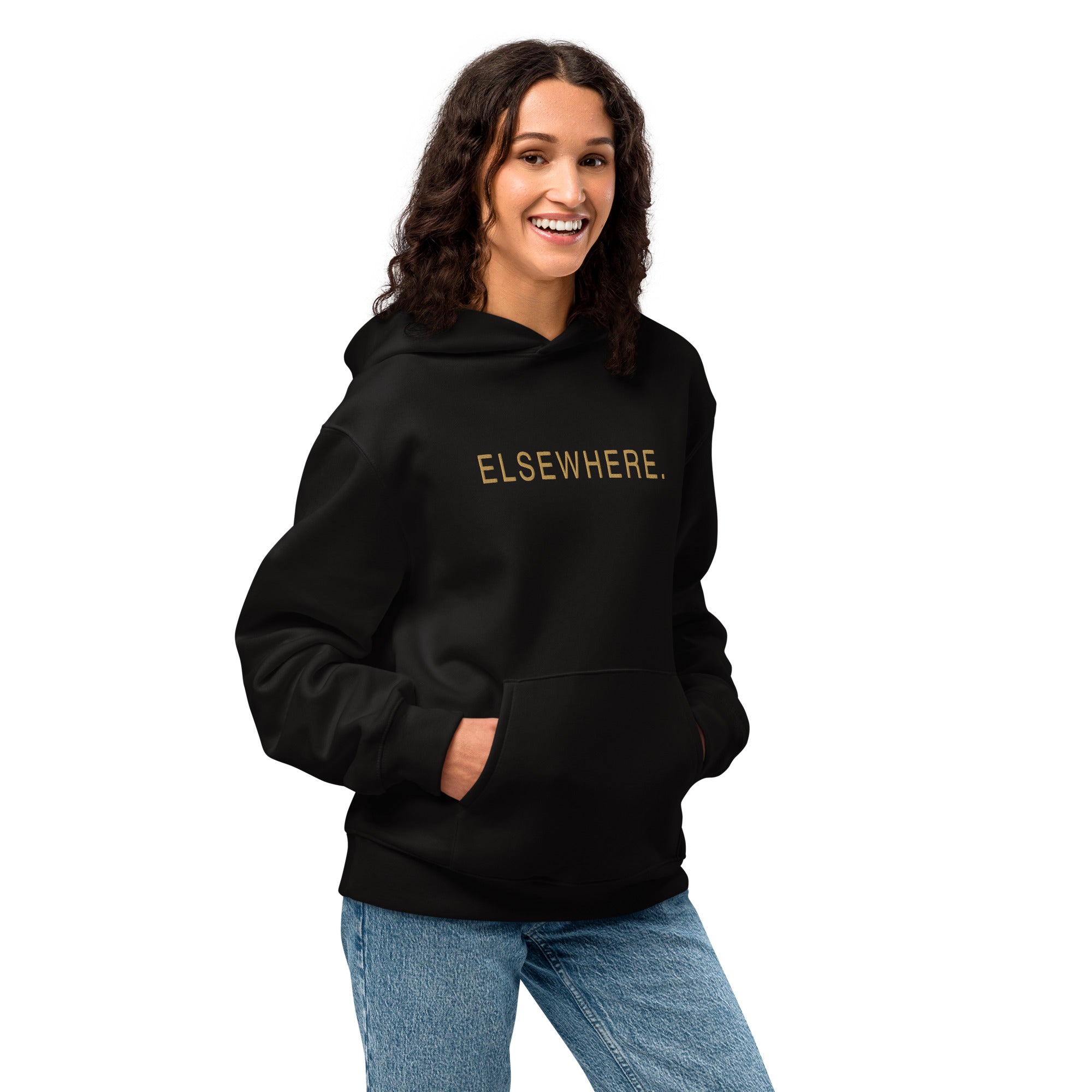 Woman wearing the oversized black Elsewhere Hoodie with gold flat embroidery.