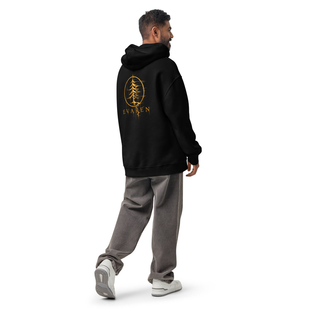 Male model wearing the black EVAREN Distortion Hoodie in an oversized fit, showing the gold graphic on the back.