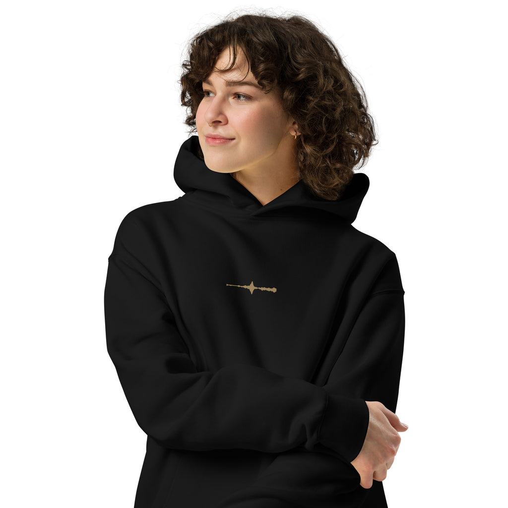 Woman wearing the black EVAREN Room Tone Hoodie from the front, showing the relaxed fit and small center-chest waveform.