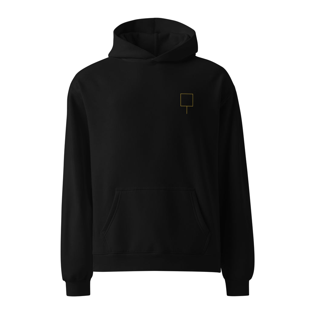 Front view of The Trap Door Hoodie in black with a small gold trap-door symbol on the left chest.