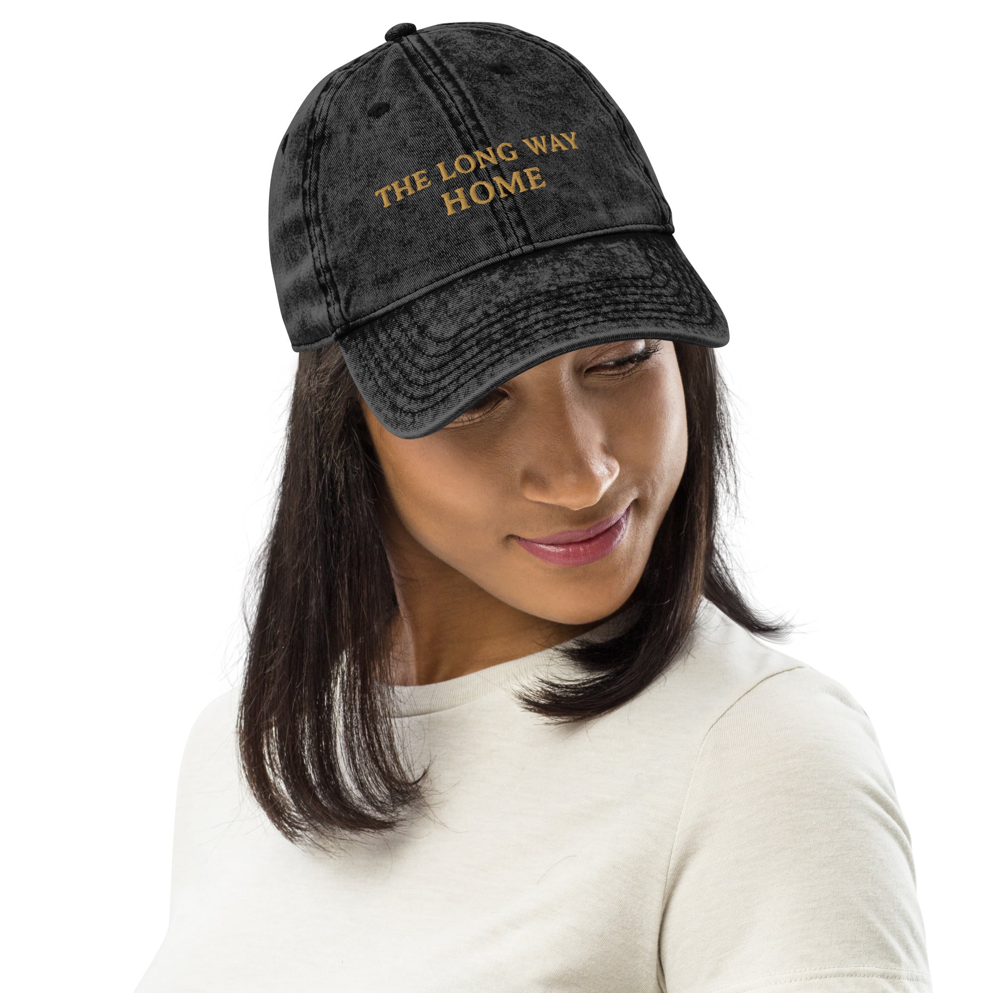 Woman wearing The Long Way Home Vintage Cap in washed black cotton twill with muted gold front embroidery.